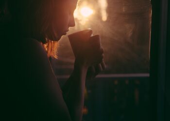 Vor Gewalt fliehende Frau mit einer Tasse in der Hand