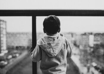 Kind vor einer Glasscheibe