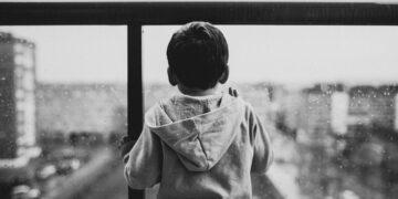 Kind vor einer Glasscheibe