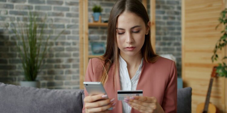 Frau in Arbeitsklamotten mit Kreditkarte