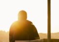 Trauriger Mensch, der in die Sonne blickt
