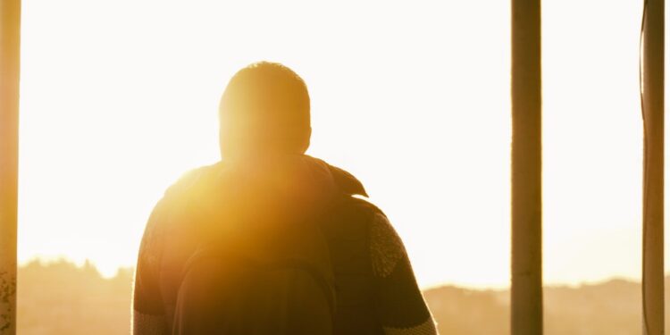 Trauriger Mensch, der in die Sonne blickt