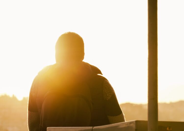 Trauriger Mensch, der in die Sonne blickt
