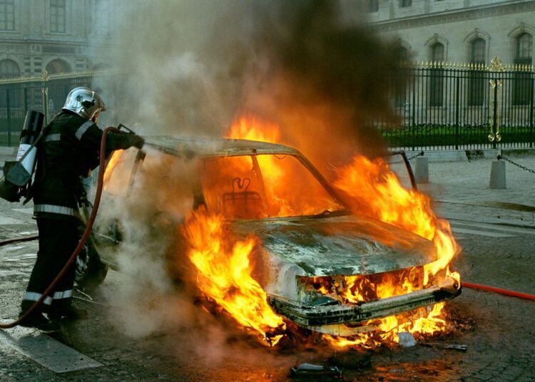 Feuerwehrmann löscht brennendes Auto